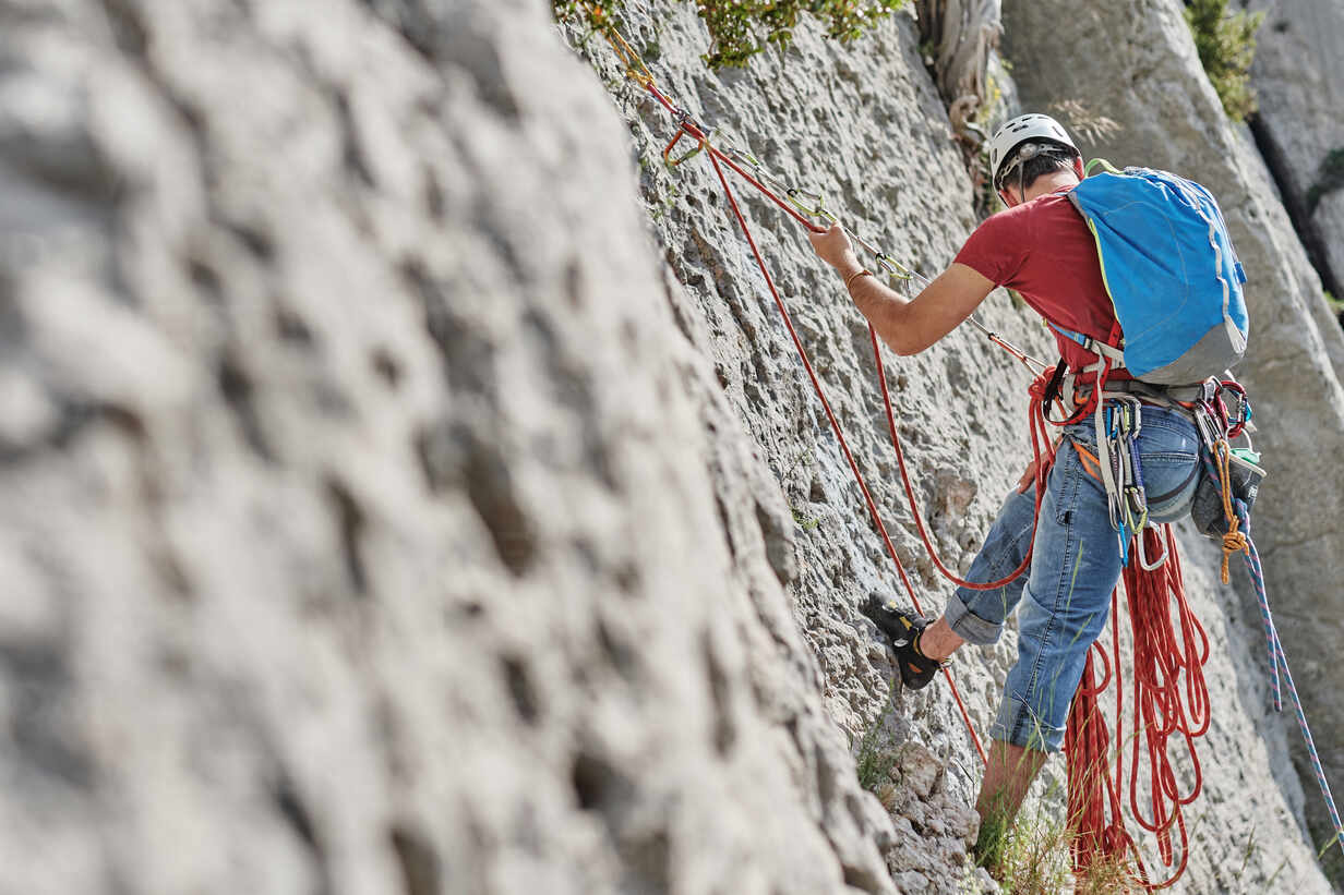 R&W Rope Sales Shop -R&W Rope Sales Shop back view of unrecognizable male mountaineer in safety equipment climbing steep rock during summer vacation ADSF15688